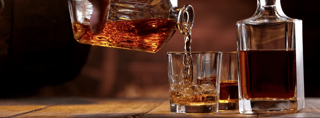 Monkey shoulder whisky being poured into a glass.